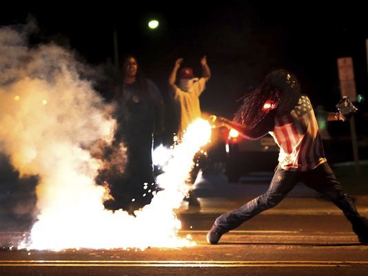 This is a photo of a protester in Ferguson, Mo. throwing tear gas back at the police during the 2014 protests. This was in reaction to the shooting of an unarmed black teen by a Ferguson police officer.