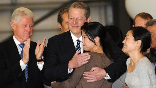 This is a photo of Vice President Al Gore hugging Laura Ling as her sister Euna Ling greets President Bill Clinton.